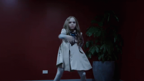 A Little Girl Is Dancing In Front Of A Potted Plant GIF