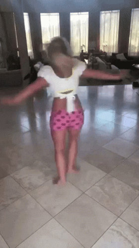 A Little Girl Is Dancing On A Tiled Floor GIF