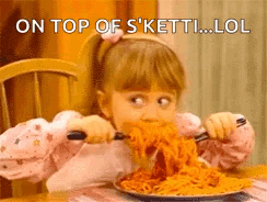 A Little Girl Is Eating A Plate Of Spaghetti With A Fork And Knife . GIF