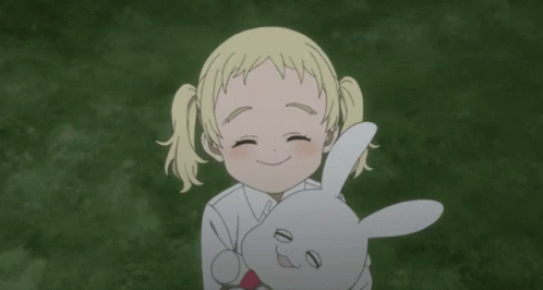 A Little Girl Is Holding A Stuffed Rabbit In Her Arms GIF