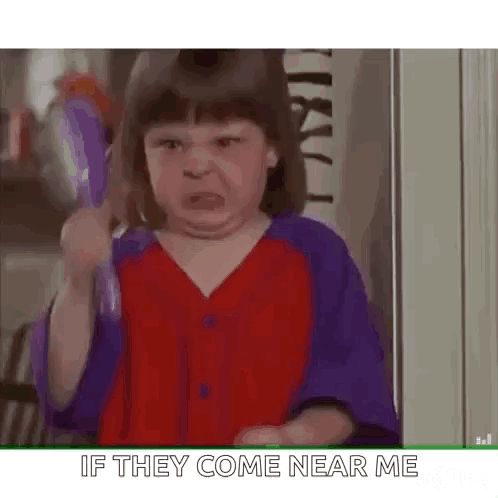 A Little Girl Is Holding A Toothbrush And Making A Face . GIF