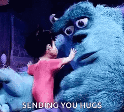 A Little Girl Is Hugging A Stuffed Animal From Monsters Inc . GIF