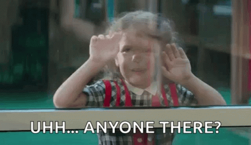 A Little Girl Is Looking Out Of A Window And Making A Funny Face With Her Hands . GIF