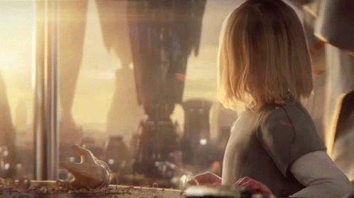 A Little Girl Is Looking Out Of A Window At A City GIF
