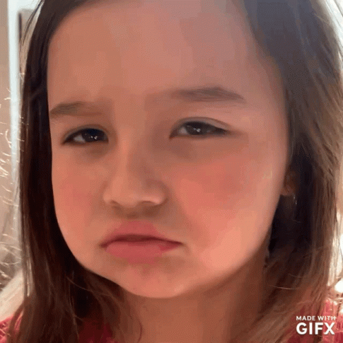 A Little Girl Is Making A Sad Face With A Gifx Watermark GIF
