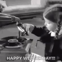 A Little Girl Is Playing A Record On A Record Player And Says `` Happy Wednesday '' . GIF