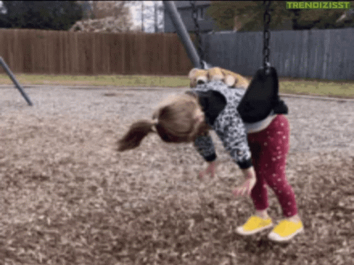 A Little Girl Is Playing On A Swing With The Words Trendizisst Written On The Bottom GIF