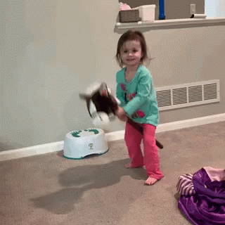 A Little Girl Is Playing With A Stuffed Animal In Front Of A Potty That Has The Number 2 On It GIF