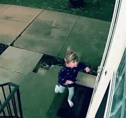 A Little Girl Is Running Down The Stairs Of A House . GIF