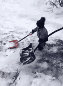 A Little Girl Is Shoveling Snow With A Shovel And A Bag . GIF