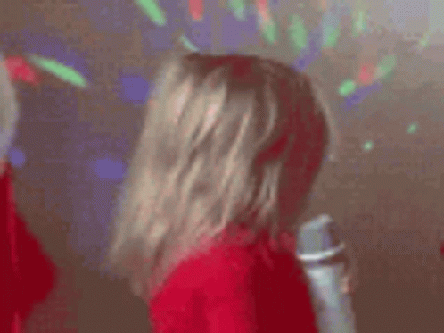 a little girl is singing into a microphone in a room .