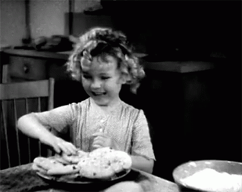 A Little Girl Is Sitting At A Table With A Bowl Of Flour And A Plate Of Food . GIF