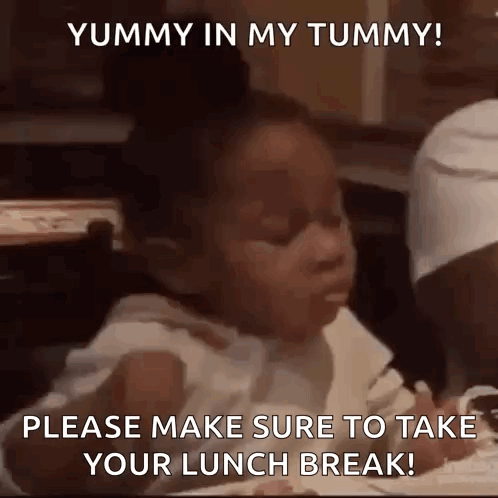A Little Girl Is Sitting At A Table With A Fork In Her Mouth Eating Food . GIF