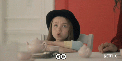 A Little Girl Is Sitting At A Table With A Netflix Logo On The Bottom GIF