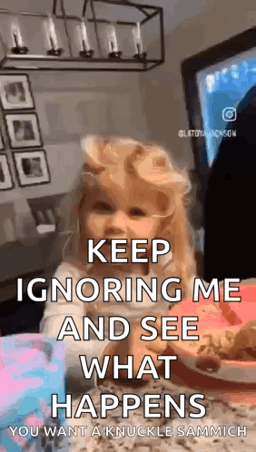 A Little Girl Is Sitting At A Table With A Sign That Says `` Keep Ignoring Me And See What Happens . '' GIF