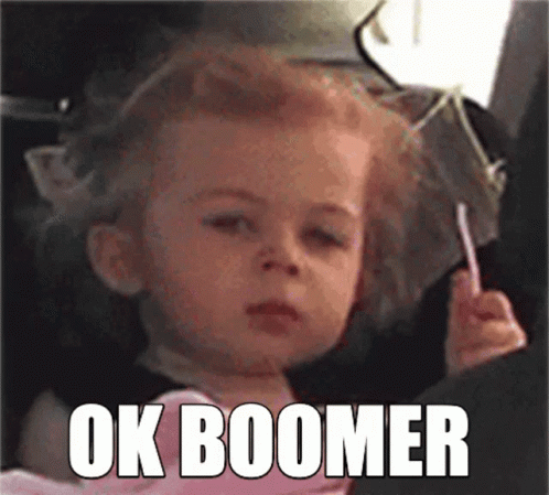 A Little Girl Is Sitting In A Car Seat Holding A Lollipop And Making A Face . GIF