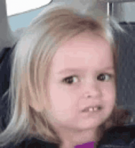 A Little Girl Is Sitting In The Back Seat Of A Car And Making A Funny Face . GIF