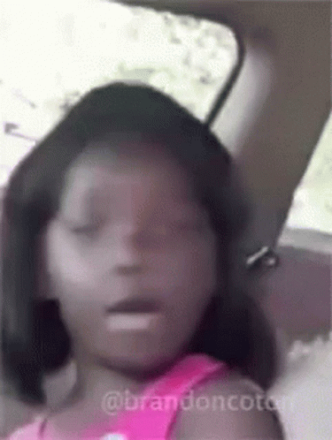 A Little Girl Is Sitting In The Back Seat Of A Car With Her Eyes Closed And Her Mouth Open . GIF