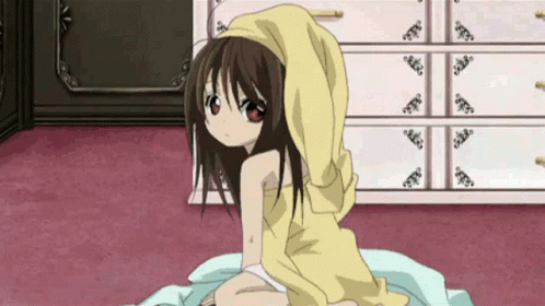 A Little Girl Is Sitting On A Bed With A Yellow Towel On Her Head . GIF