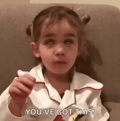 A Little Girl Is Sitting On A Couch Eating A Candy Bar And Saying `` You 'Ve Got This ! '' GIF