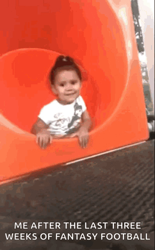 A Little Girl Is Sitting On An Orange Slide With The Caption Me After The Last Three Weeks Of Fantasy Football GIF