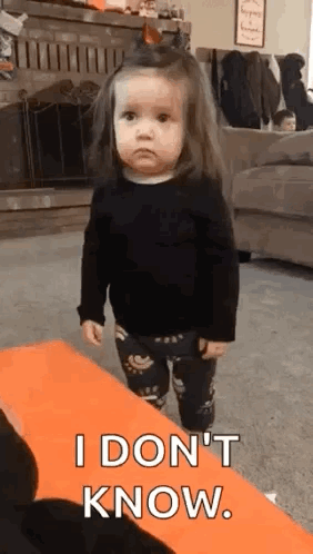 A Little Girl Is Standing In A Living Room And Making A Funny Face . GIF