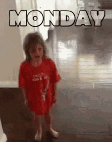 A Little Girl Is Standing In Front Of A Sign That Says Monday GIF