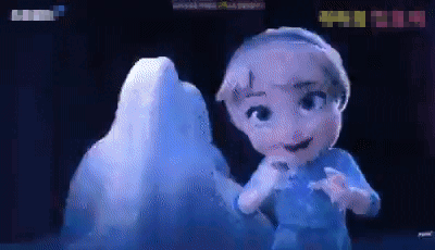 A Little Girl Is Standing In Front Of An Ice Sculpture GIF