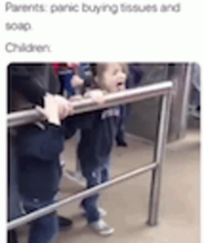 A Little Girl Is Standing Next To A Railing On A Subway Train . GIF