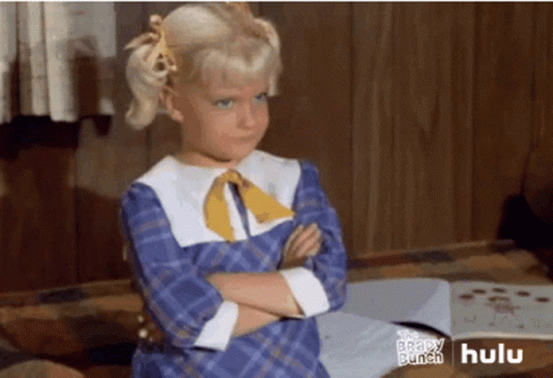 A Little Girl Is Standing With Her Arms Crossed In Front Of A Hulu Ad GIF
