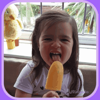 A Little Girl Is Sticking Her Tongue Out While Eating An Ice Cream GIF