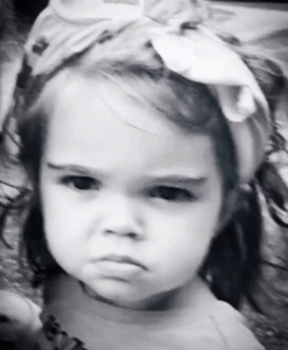 A Little Girl Is Wearing A Headband And Making A Funny Face GIF
