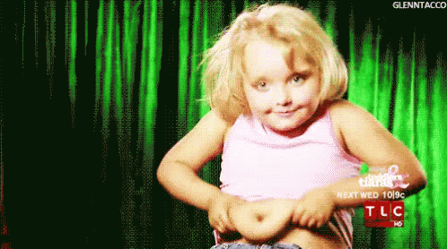 A Little Girl Shows Off Her Stomach In Front Of A Green Curtain That Says Tlc On It GIF