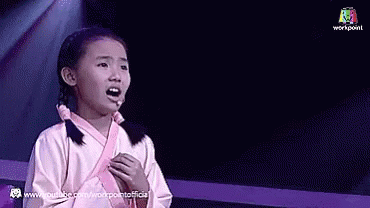 A Little Girl Singing Into A Microphone On Stage GIF