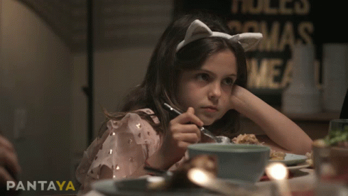 a little girl sitting at a table with a fork in her hand and the word pantaya on the bottom right