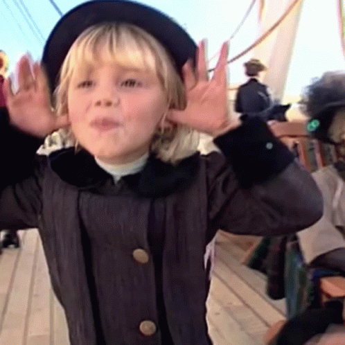 A Little Girl Wearing A Black Hat And A Black Coat GIF