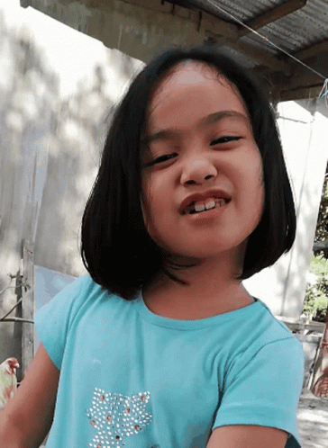 A Little Girl Wearing A Blue Shirt With A Butterfly On It GIF