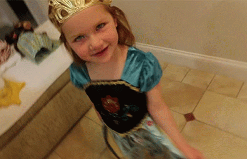 A Little Girl Wearing A Dress And A Crown GIF