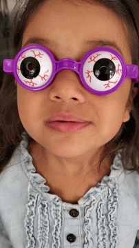 A Little Girl Wearing A Pair Of Purple Glasses With Fake Eyes GIF