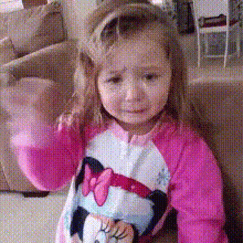A Little Girl Wearing A Pink Minnie Mouse Shirt GIF