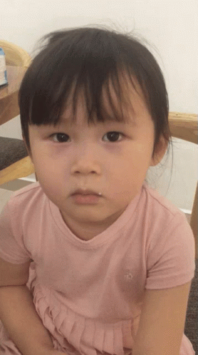 A Little Girl Wearing A Pink Shirt With A Penguin On The Front GIF