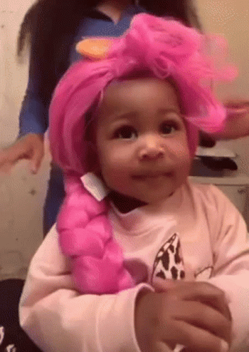 A Little Girl Wearing A Pink Wig And A Pink Braid . GIF