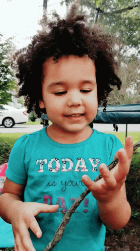 A Little Girl Wearing A Shirt That Says Today Is Your Day Is Holding A Stick GIF