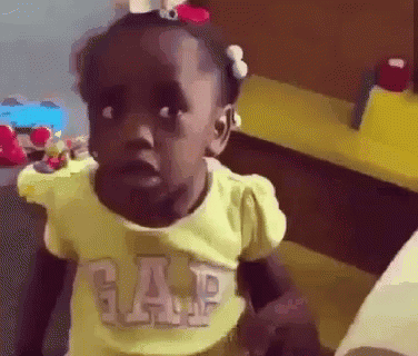A Little Girl Wearing A Yellow Gap Shirt Is Making A Face . GIF
