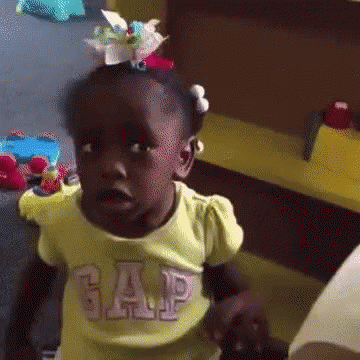 A Little Girl Wearing A Yellow Gap Shirt Is Making A Funny Face GIF