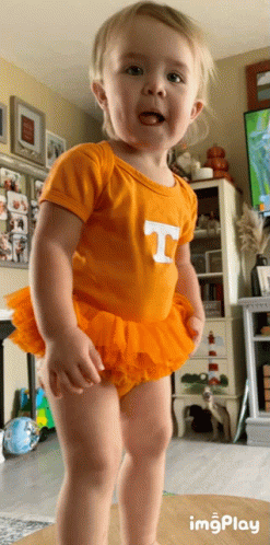 A Little Girl Wearing An Orange T-Shirt And Orange Tutu GIF