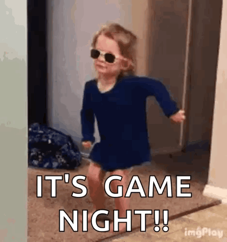 A Little Girl Wearing Sunglasses And A Blue Shirt Is Running In A Hallway . GIF
