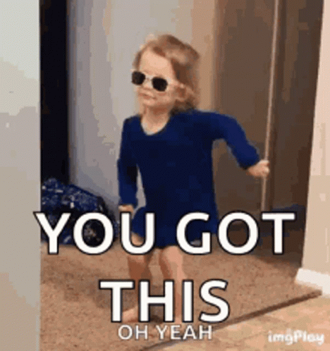 A Little Girl Wearing Sunglasses And A Blue Shirt Is Walking In A Doorway . GIF