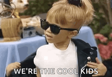 A Little Girl Wearing Sunglasses And A Leather Jacket . GIF