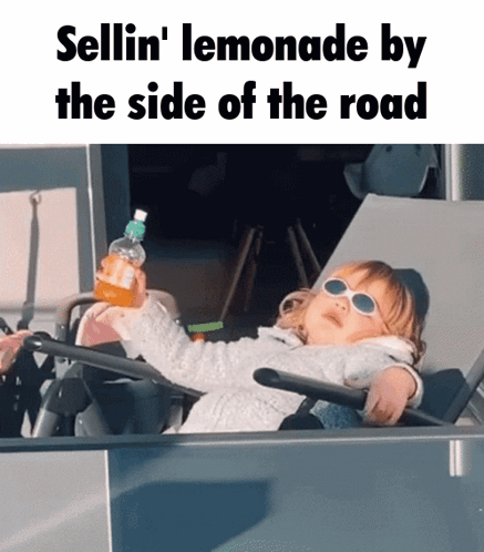 a little girl wearing sunglasses is sitting on a chair holding a bottle of lemonade